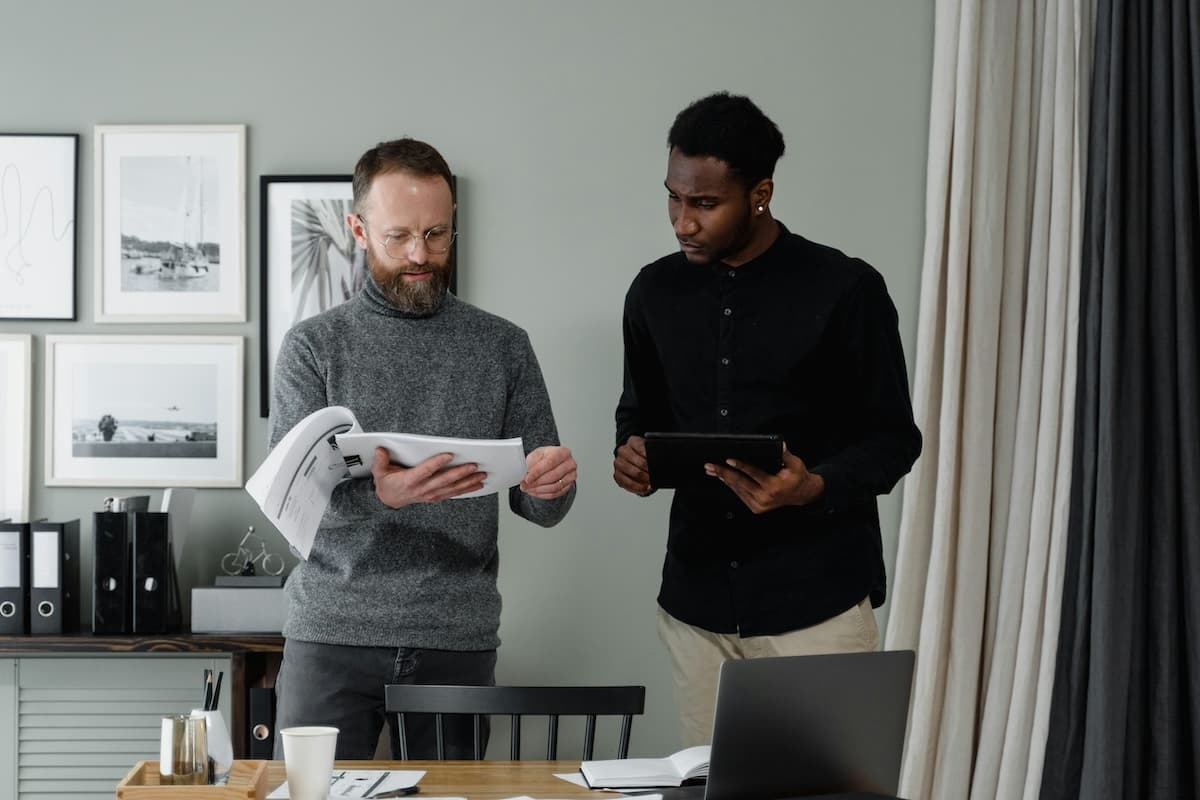 Two people holding notebooks and having a discussion